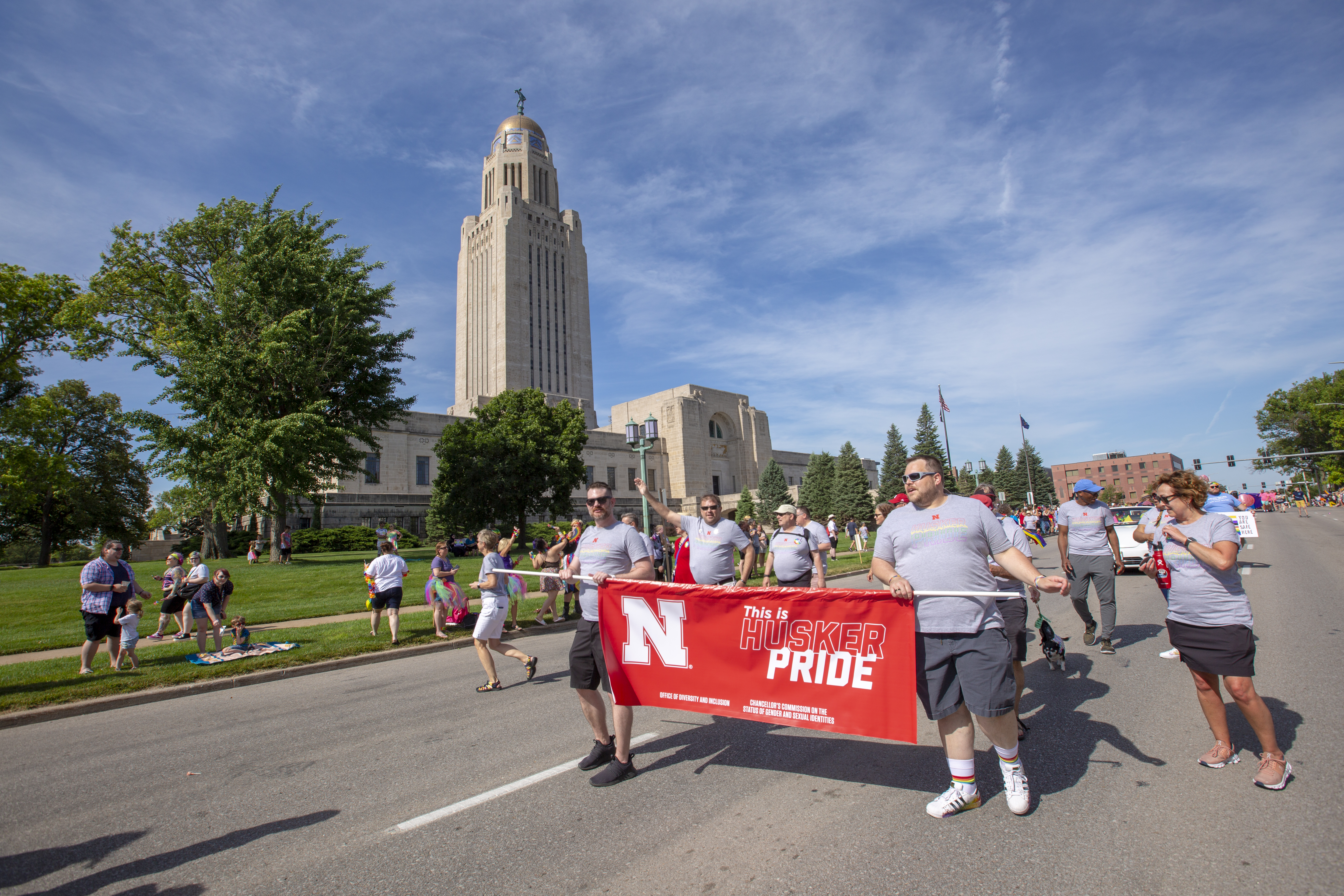 huskers marching in pride parade with banner