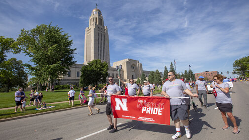 huskers marching in pride parade with banner