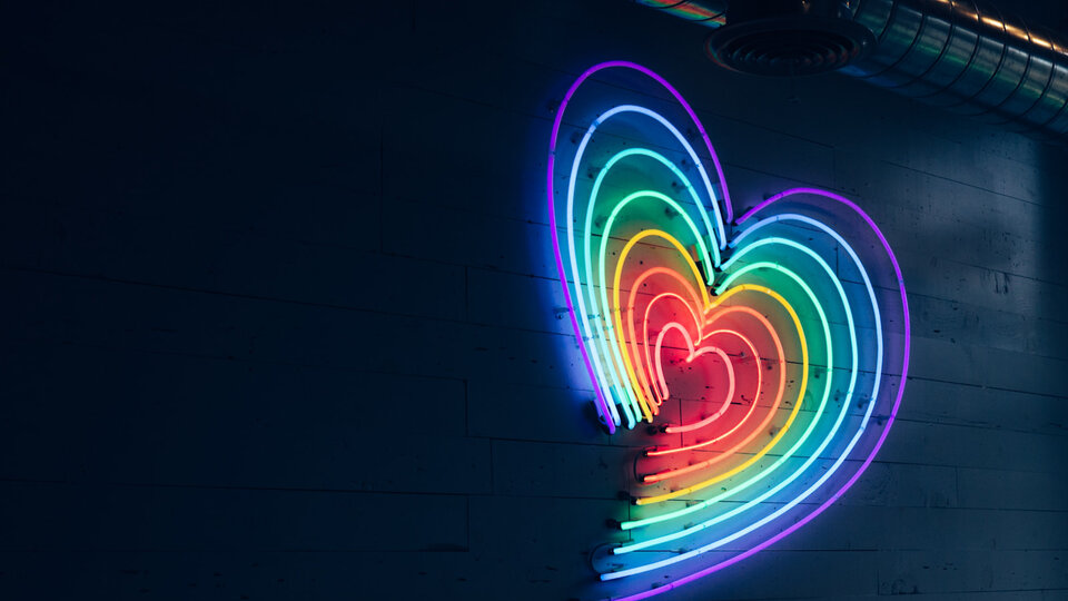 neon heart in rainbow colors on the side on building
