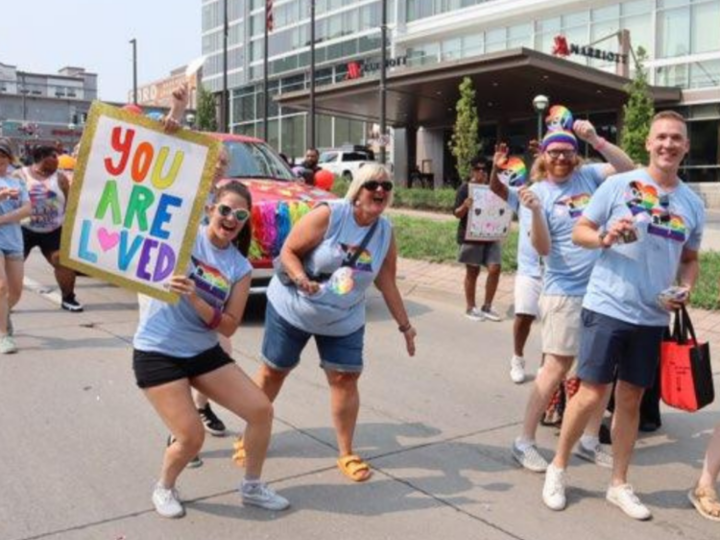 nap volunteers at Omaha pride holding sign