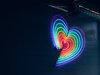 neon heart in rainbow colors on the side on building